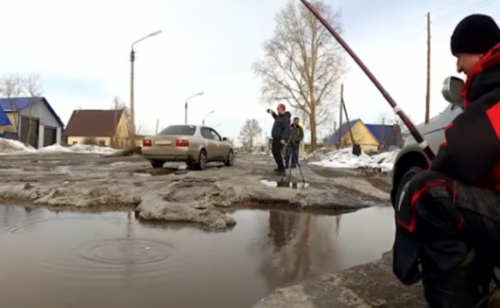 Ловись, рыбка: житель Алтайского края рыбачил в дорожной яме. Видео